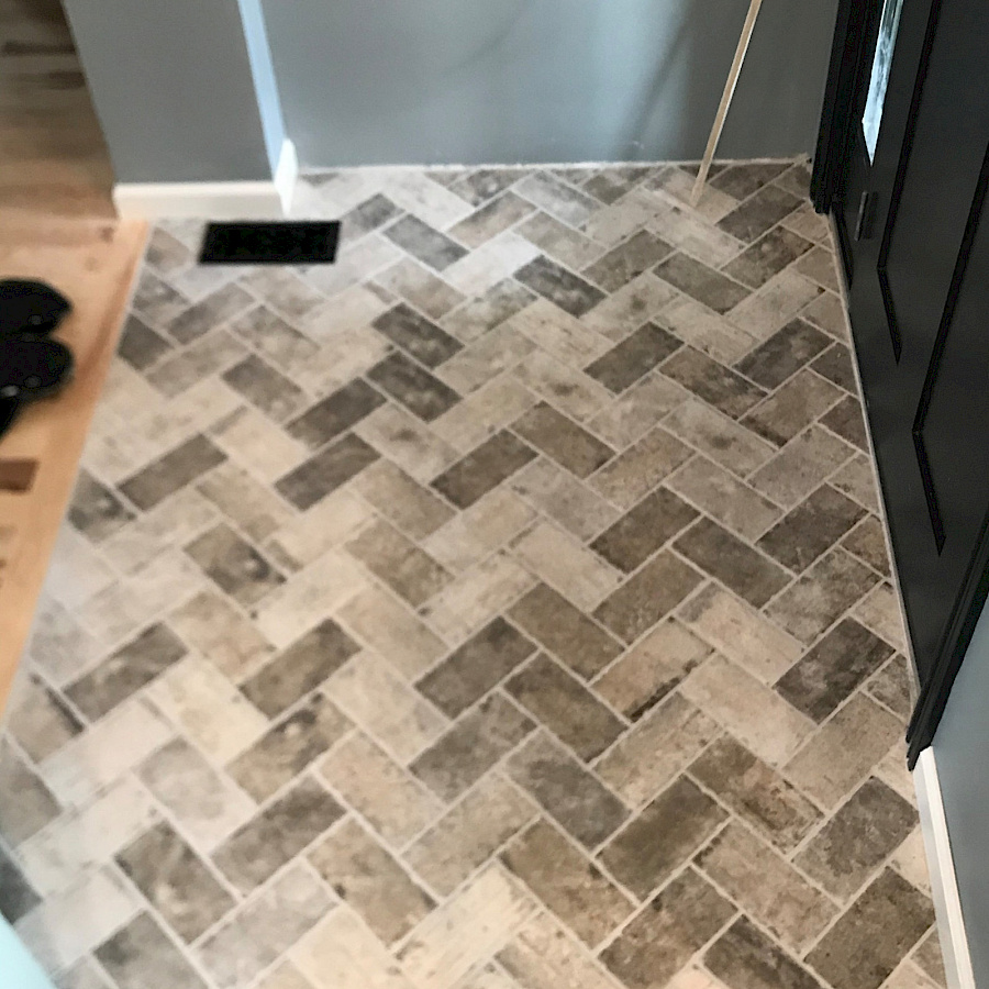 Herringbone tile floor in a remodeled bathroom by Sparrow Contracting in southeast Michigan