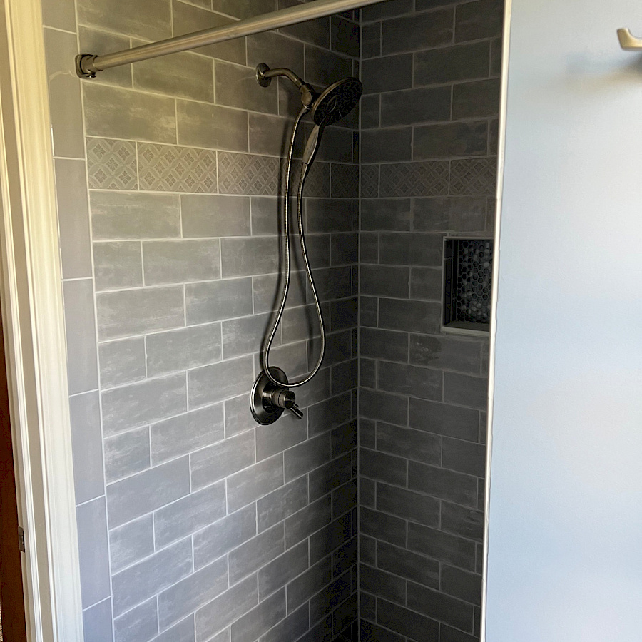 Tiled walk-in shower in a twin bathroom remodel in Ann Arbor, Michigan by Sparrow Contracting