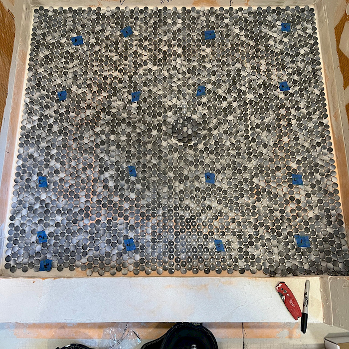 Hexagon mosaic tile floor being installed in a bathroom remodel by Sparrow Contracting